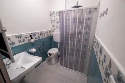 a bathroom with a shower and a toilet and a sink at Room 112 Oltremare in Bagheria