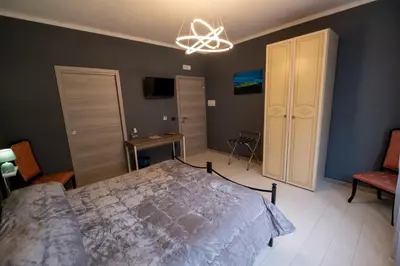 a bedroom with a bed and a chandelier at Room 112 Oltremare in Bagheria