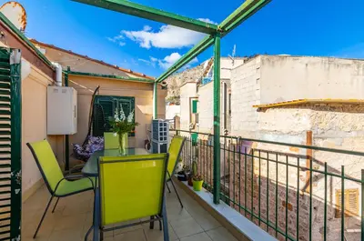 a small balcony with a table and chairs on it at GuestHost - Sea View Charm - Mondello Apartment with Terrace in Palermo