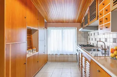 a kitchen with wooden cabinets and a sink and a window at GuestHost - Sea View Charm - Mondello Apartment with Terrace in Palermo