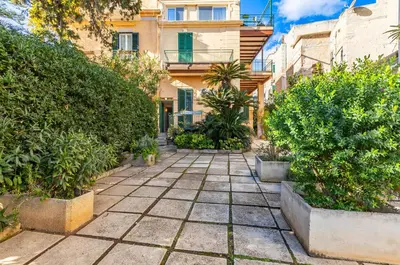 a courtyard with plants in front of a building at GuestHost - Sea View Charm - Mondello Apartment with Terrace in Palermo