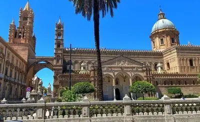 a large building with a palm tree in front of it at Dome Suite La Cupoletta in Palermo