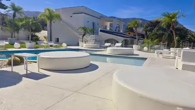 a pool with white tables and chairs next to a building at My Place B&B in Carini