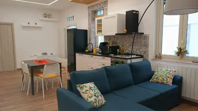 a living room with a blue couch and a kitchen at Palermo case vacanza in Palermo