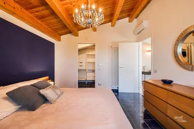 a bedroom with a large bed and a chandelier at Villa DellAlbero in Alcamo