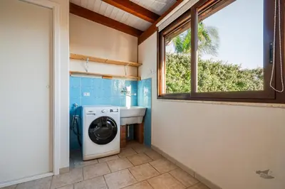 a bathroom with a washing machine and a sink at Villa DellAlbero in Alcamo