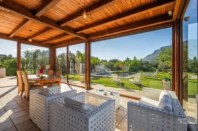 a patio with a table and chairs and a large window at Villa DellAlbero in Alcamo