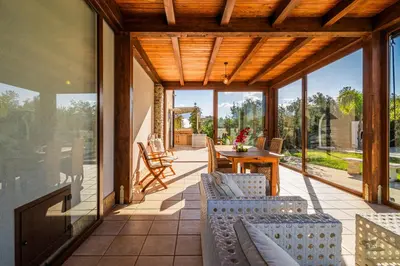 a screened porch with a table and chairs on it at Villa DellAlbero in Alcamo