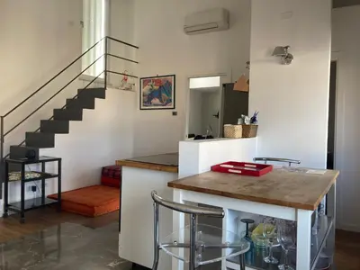 a kitchen with a staircase and a counter with stools at Casa levante in Palermo