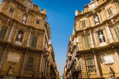 a large building with a clock tower and a cathedral at Centro Storico - Casetta al Capo in Palermo