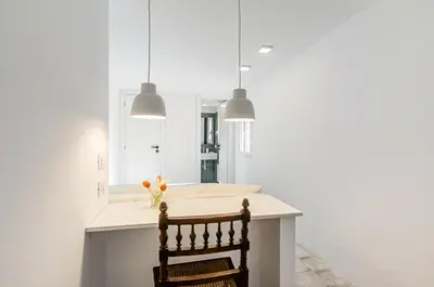 a kitchen with two pendant lights and a chair at GuestHost - Alle Terrazze Blu - Mondello Sea View Apartment in Palermo