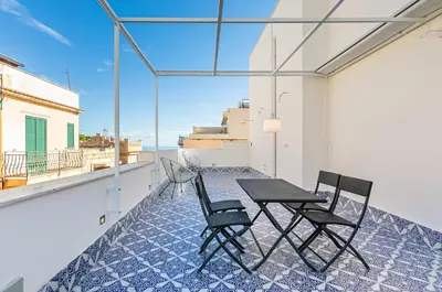 a patio with a table and chairs on a balcony at GuestHost - Alle Terrazze Blu - Mondello Sea View Apartment in Palermo