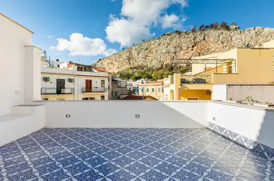 a view from the roof of a building with a mountain in the background at GuestHost - Alle Terrazze Blu - Mondello Sea View Apartment in Palermo