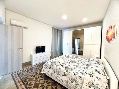 a bedroom with a large bed and a television at Casa Nonna Anna in Palermo