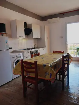 a kitchen with a table and chairs and a kitchen with a refrigerator at Residence Marino in Balestrate