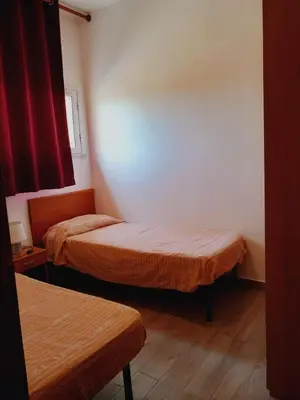 two beds in a small room with red curtains at Residence Marino in Balestrate