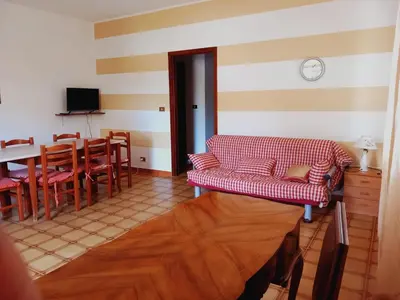 a living room with a couch and a table and chairs at Residence Marino in Balestrate