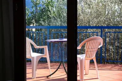 two chairs and a table on a porch with a table at Solemar Sicilia - Villa Mariù in Palermo