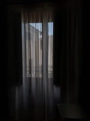 a window with white curtains in a dark room at Affittacamere La Cartiera in Palazzo Adriano