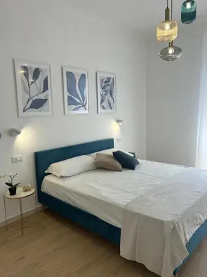 a kitchen with a table and two blue chairs at Antò 2.0 in Castellammare del Golfo