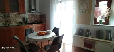 a kitchen with a table and chairs in a room at La casetta di Giò Giò appartamento in centro a Monreale in Monreale