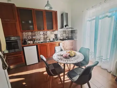 a kitchen with a table and chairs in a kitchen at La casetta di Giò Giò appartamento in centro a Monreale in Monreale