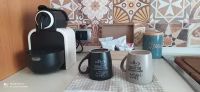 a kitchen counter with two coffee mugs and a toaster at La casetta di Giò Giò appartamento in centro a Monreale in Monreale
