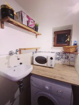a kitchen counter with a microwave and a sink at La casetta di Giò Giò appartamento in centro a Monreale in Monreale