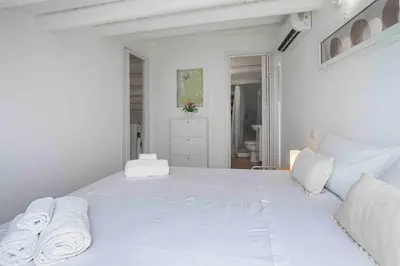 a white bedroom with a large bed with towels on it at Sky Terrace Mondello Beach house in Palermo