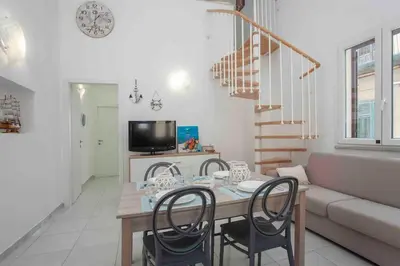 a living room with a table and chairs and a couch at Sky Terrace Mondello Beach house in Palermo