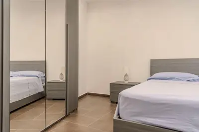 a bedroom with two beds and a mirror at Casetta dei Colori - Apartament in Palermo