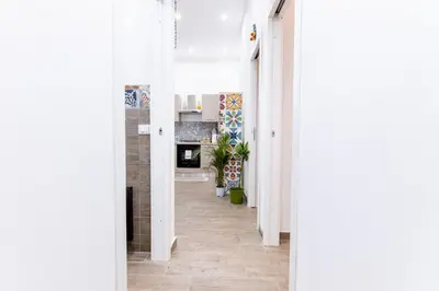 a hallway with white walls and a floor with tiles at Al Cortile del capo in Palermo