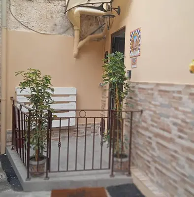 two potted plants on a fence next to a building at Al Cortile del capo in Palermo