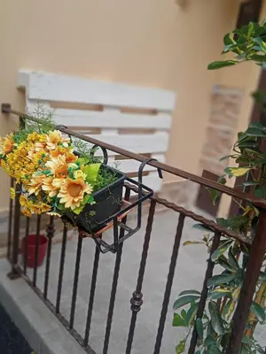 a basket of flowers on a fence at Al Cortile del capo in Palermo