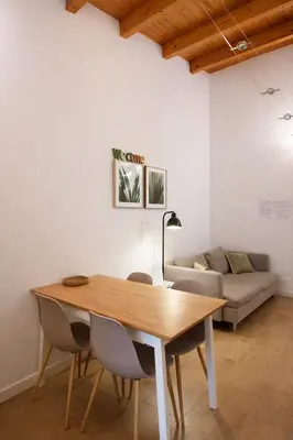 a table and chairs in a living room with a couch at Downtown Maqueda in Palermo