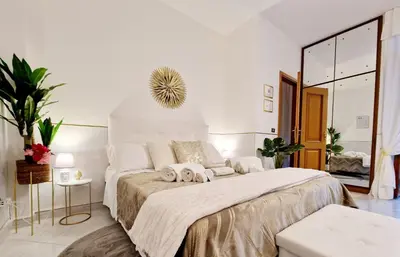 a white bedroom with a large bed and a mirror at Politeama Dependance in Palermo