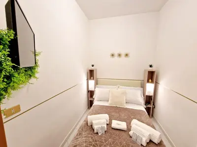 a room with a bed and a flat screen tv at Politeama Dependance in Palermo