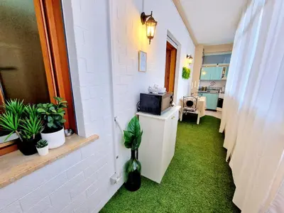 a hallway with green grass and a room with a microwave at Politeama Dependance in Palermo