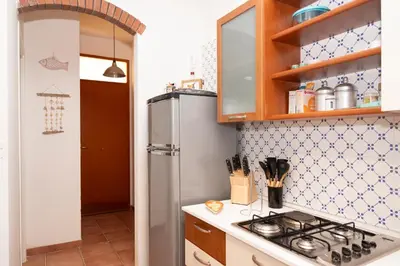 a kitchen with a stove and a refrigerator at Casa Za Lisa con Vista Mare a Macari in Macari