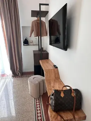 a room with a table and a television and a chair at Suites Cavour holiday dream in Palermo
