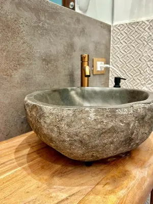 a bathroom with a stone sink on a wooden counter at Suites Cavour holiday dream in Palermo