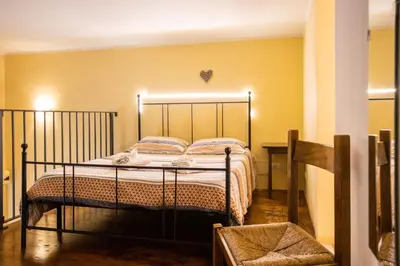 a bedroom with a bed in a room with yellow walls at Hola House alla Magione in Palermo