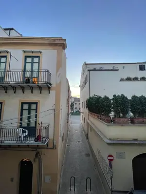 an alley between two buildings with plants on the balconies at Hola House alla Magione in Palermo