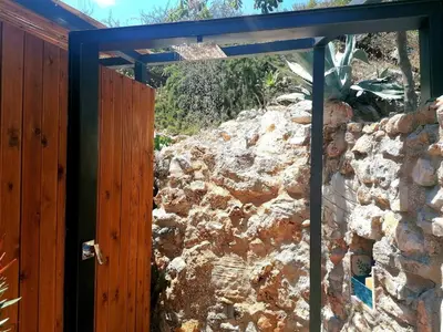 an opening in a stone wall with a wooden door at B&B Tre Giummare in Scopello