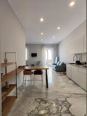 a kitchen and living room with a table and chairs at Lily Apartments in Palermo