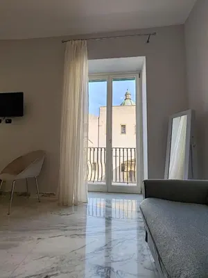 a living room with a couch and a large window at Lily Apartments in Palermo
