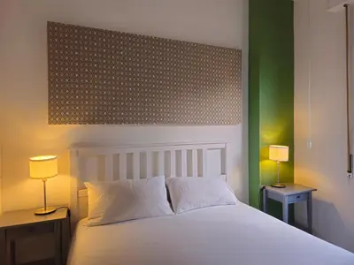 a bedroom with a white bed with two lamps on tables at Palermo Belmonte Florio in Palermo