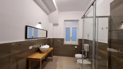a bathroom with two toilets and a sink and a shower at Palermo Belmonte Florio in Palermo