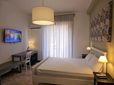 a hotel room with a bed and a desk and a bedroom at Palermo Belmonte Florio in Palermo