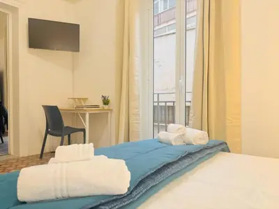 a bedroom with a bed with a chair and a window at Calamari37 in Palermo